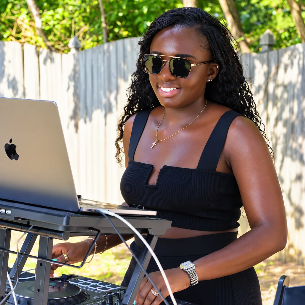 DJ Akuaa performing a sunlit outdoor DJ set